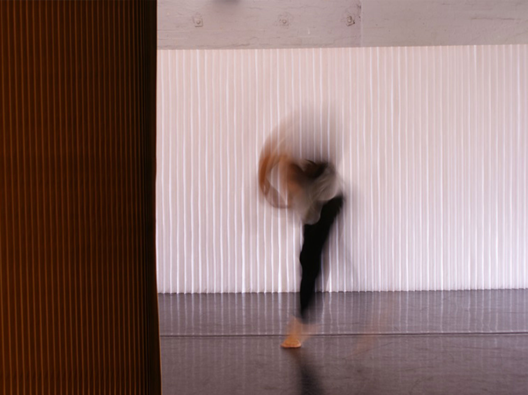 A contemporary dancer blurred against a white abstract background